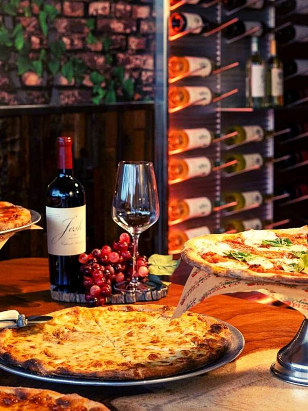 A table at a wine club pizza restaurant in Pompano Beach with a wine rack in the background